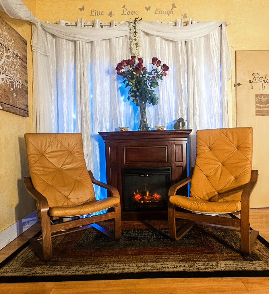 A cozy fireplace in the party room at Hands On HealthCare Massage Therapy in Commack, Long Island, creating a warm ambiance.