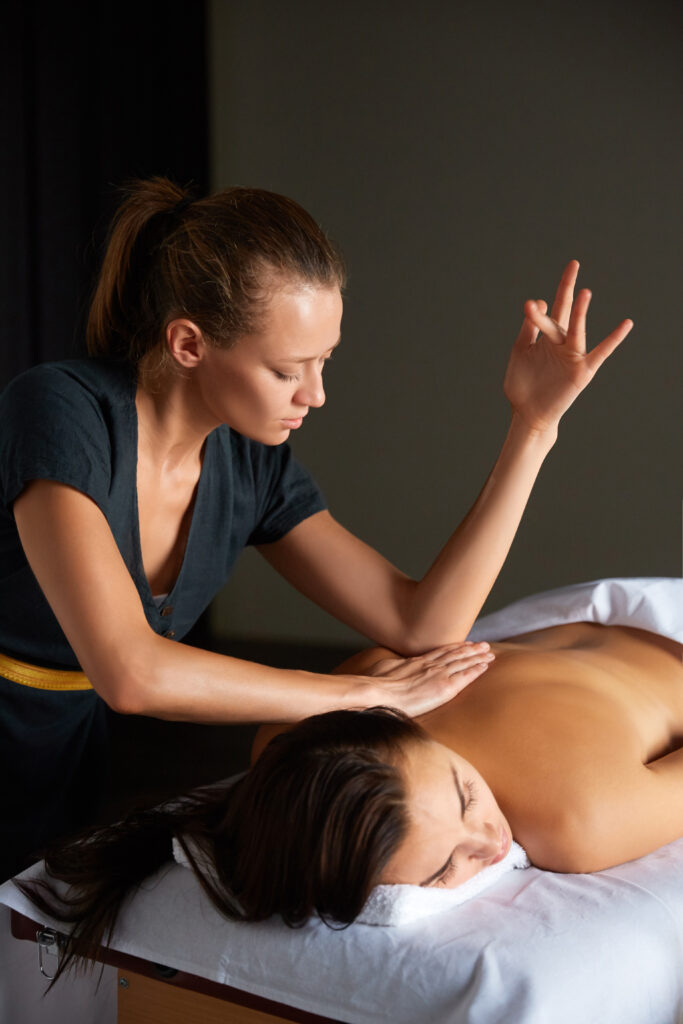 A therapist consulting with a client during a session at Hands On HealthCare Massage Therapy in Commack, Long Island.