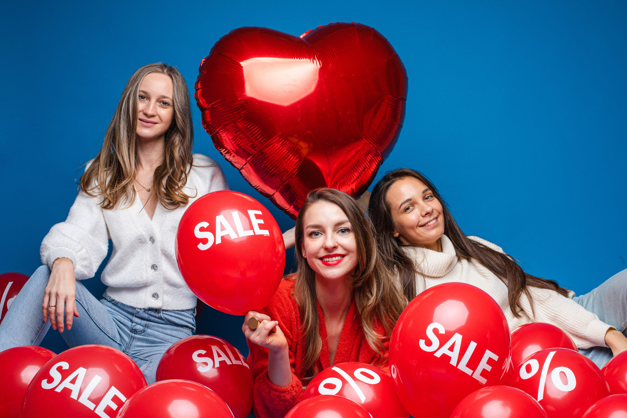 Women holding balloons that say “Sale” to promote monthly spa specials at Hands On HealthCare Massage Therapy in Commack, Long Island.