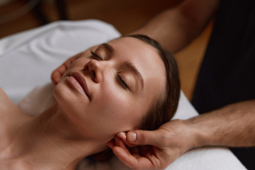 A client receiving a relaxing spa treatment with a facial massage at Hands On HealthCare Massage Therapy in Commack, Long Island.